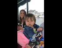 Baby in dads arms looks around angry on boat