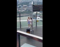 Man spins camera and points at woman