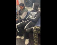 Person rides train skeleton costume holds dildo
