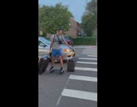 Guy rides skateboard with two rolling suitcases 