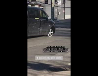 Black van drives down the street without a tire