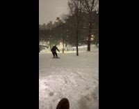 Person snowboarding at park cheered by friends