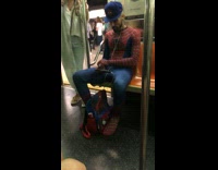 man in spiderman suit and back pack blue hate subway