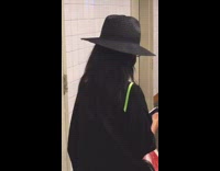 Lady dressed as Elphaba near Wicked poster 