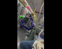 Guy riding subway sits on blue scooter