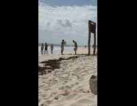 Man shirtless swing around large sledgehammer beach