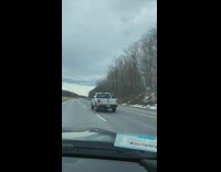 Guy driving with wooden cross out window and trump sign