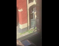 Girl poses by closed building white shirt 