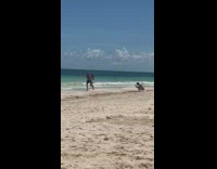 Guy jump shot woman run towards beach
