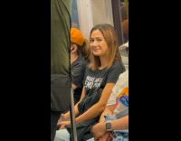 Woman reacts to man lean back on pole