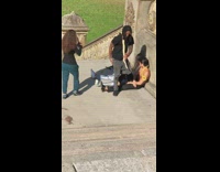 Two shirtless guys pose with snake at park