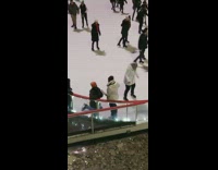 man proposes to woman on ice rink