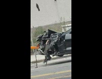 Black convertible Chevy Camaro car gets into car crash, front hood destroyed and towed by tow truck