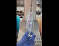 Filling blue and pink lotion into clear bottle