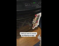 Guy flips egg in pan fails falls on stove