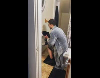 Guy holds cat against toilet paper and tells it no