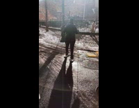 Girl wears white snowshoes to cross street 