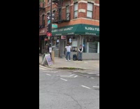 Guy grooves to music from speaker outside market 