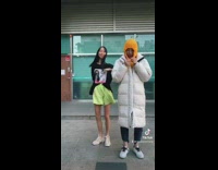 Woman dancing while other one tightens hoodie