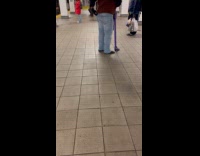 Person standing holds purple Elvis boot cane