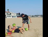 Beach guy breaks watermelons on abs sand