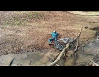Blue/Green Sweater Boy Tries to Jump Creek In Woods But Goes Over Handlebars