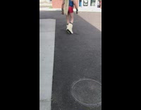 Man in blue top walks and red shorts walks into store, american flag truck