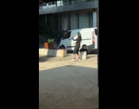 Woman with headphones dances near white van