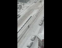 Guy riding bike in the middle of the snow covered road 
