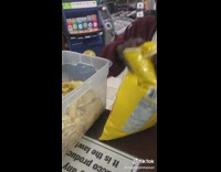 Man eats chips out of container at store