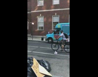 Guy wearing ruffles raps next to blue bus 