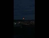 Orange moon seen in the dark horizon