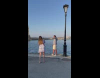 Guy in blue and white poses with view of water 
