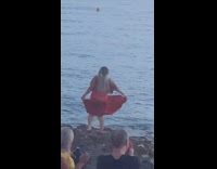 Girl wearing red skirt poses by water