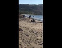 Girl lays back sand black bathing suit 