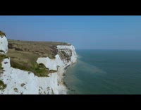 Drone shot coastline two guys on cliff