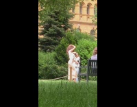 White jumpsuit girl brown building black bench 