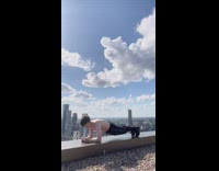 Guy exercises on rooftop ledge 
