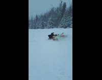 Skier rides down slope, jumps onto inflatable bed and sleds down hill