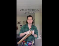 Guy in green flannel balloon artist makes bow and arrow 