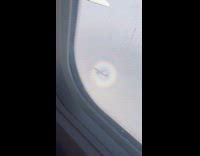 Airplane shadow in circular rainbow view window