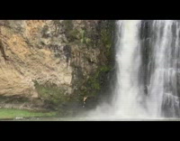 Woman climb slippery wall near waterfalls pictorial