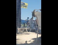 Blue shirt girl dances yellow flag sand 