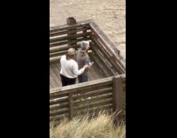 Elderly takes picture of bottle at beach