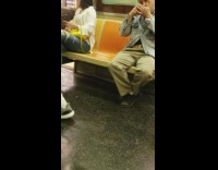 Man picks nose with keys and covers it with hand on subway train
