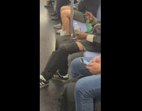 Guy sits black pants pulled down subway 