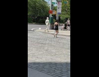 Person wears white bodysuit and mask 