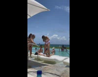 Friends sprinkle pool water woman on bed