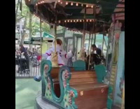 Astronaut rides carousel and waves arms and legs 