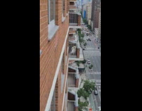 Human like figure wearing gold jacket on balcony 